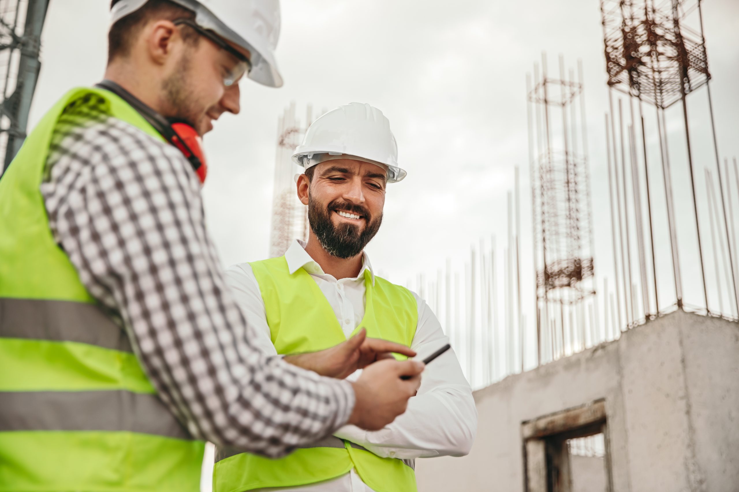Professional construction engineers using smartphone